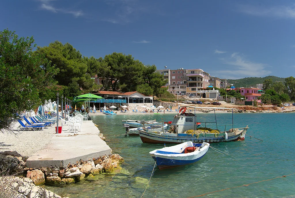 Small boats moored in a turquoise cove at Ksamil.
