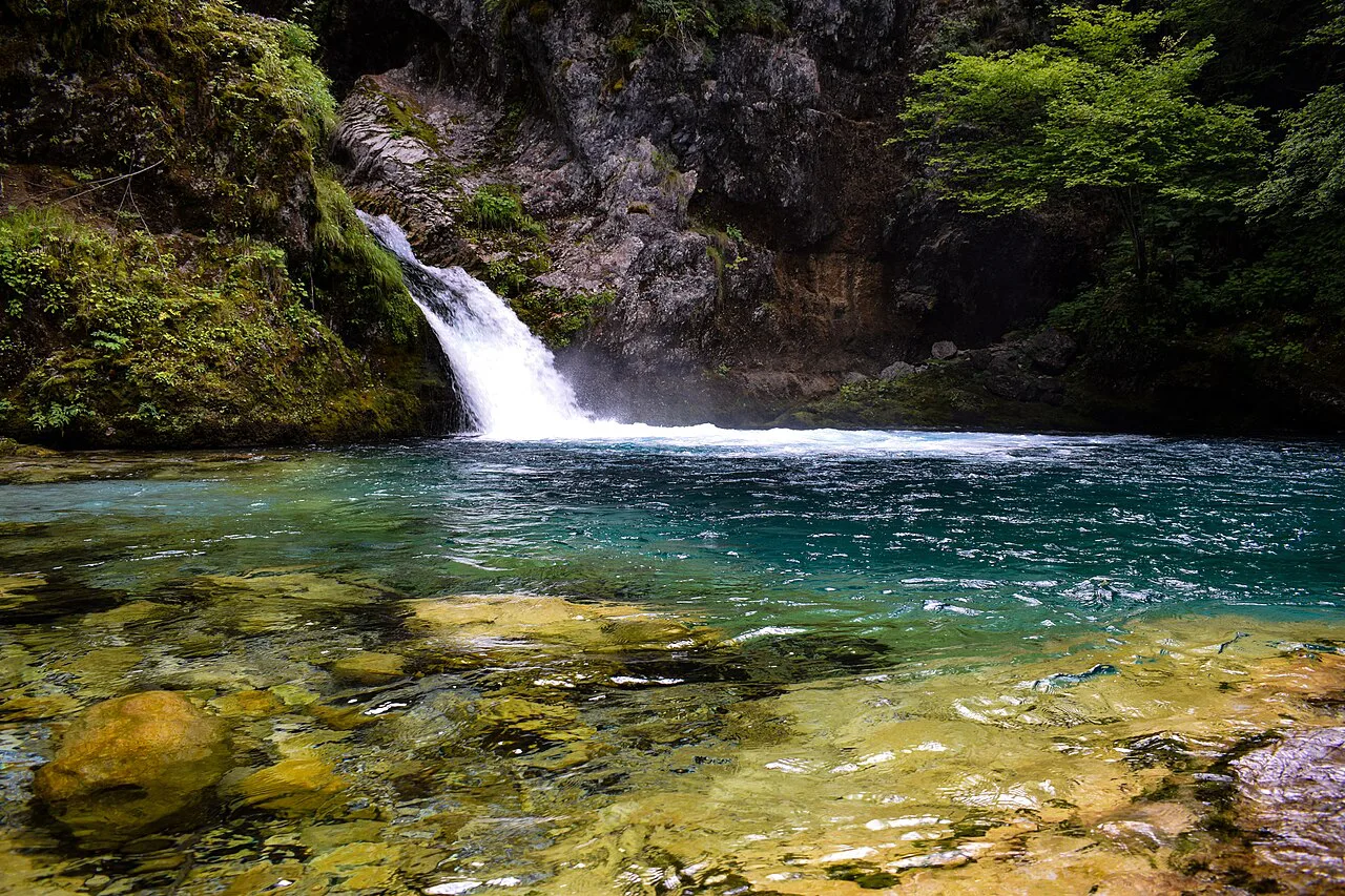A waterfall pouring into the Blue Eye pool near Theth.