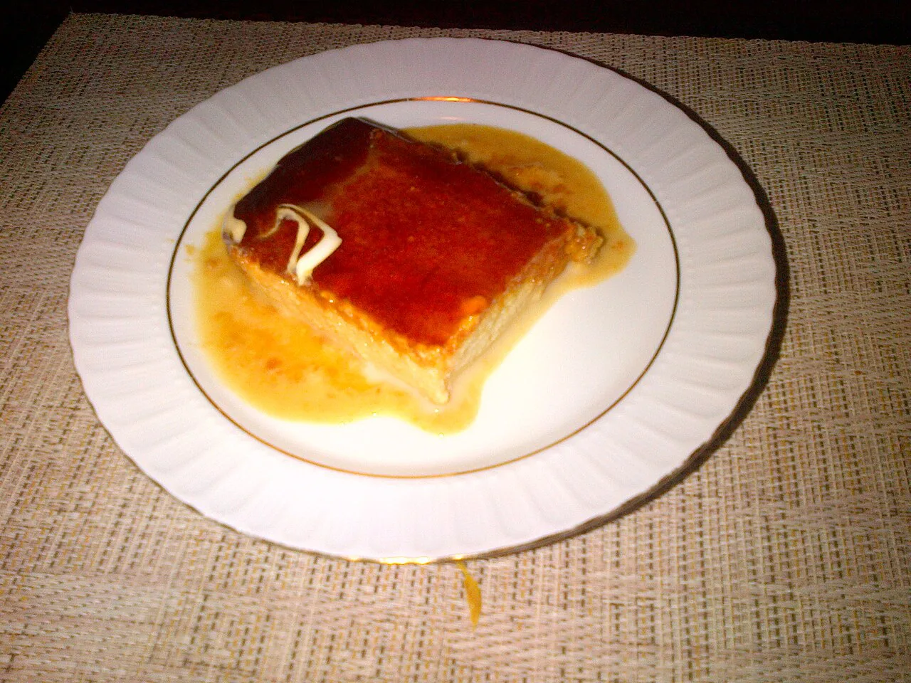 A slice of trileçe topped with caramel.