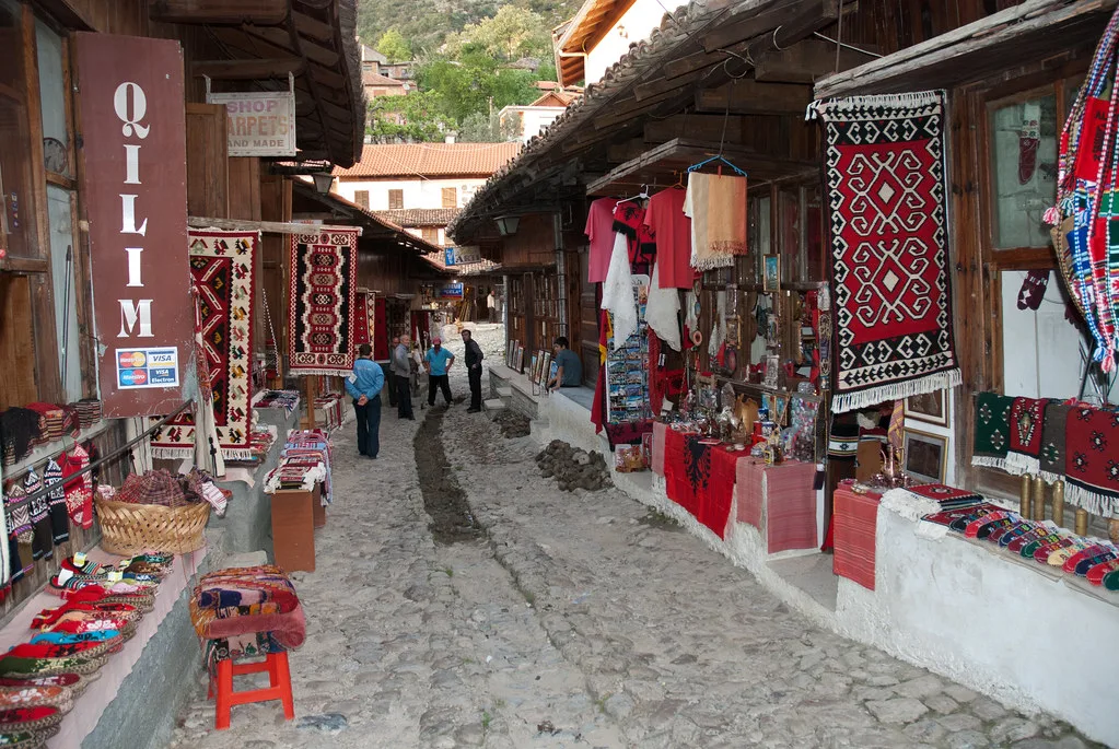 Stalls hung with carpets and textiles in a traditional Albanian bazaar street.