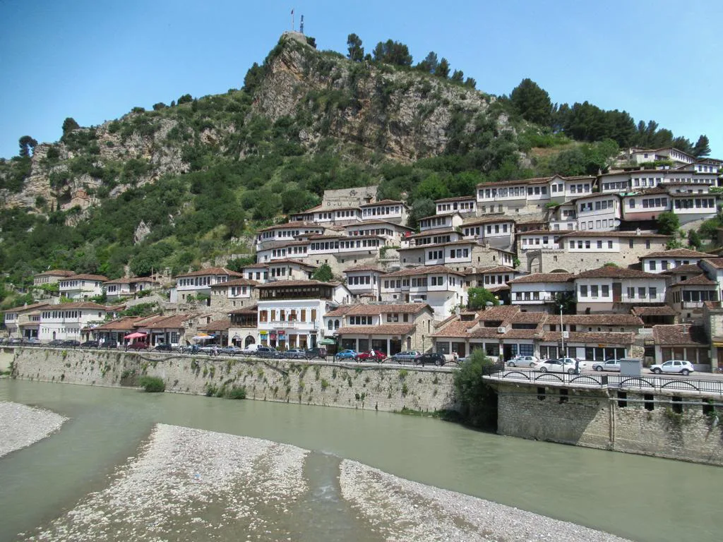 White Ottoman houses climbing the hillside between the Osum River and Berat Castle.