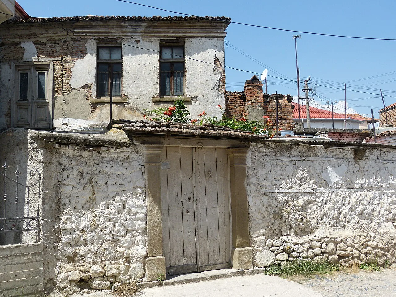 An old stone house with a wooden gate in Korçë's old town.
