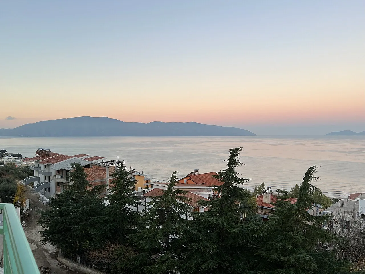 Vlorë rooftops and the bay in soft morning light.