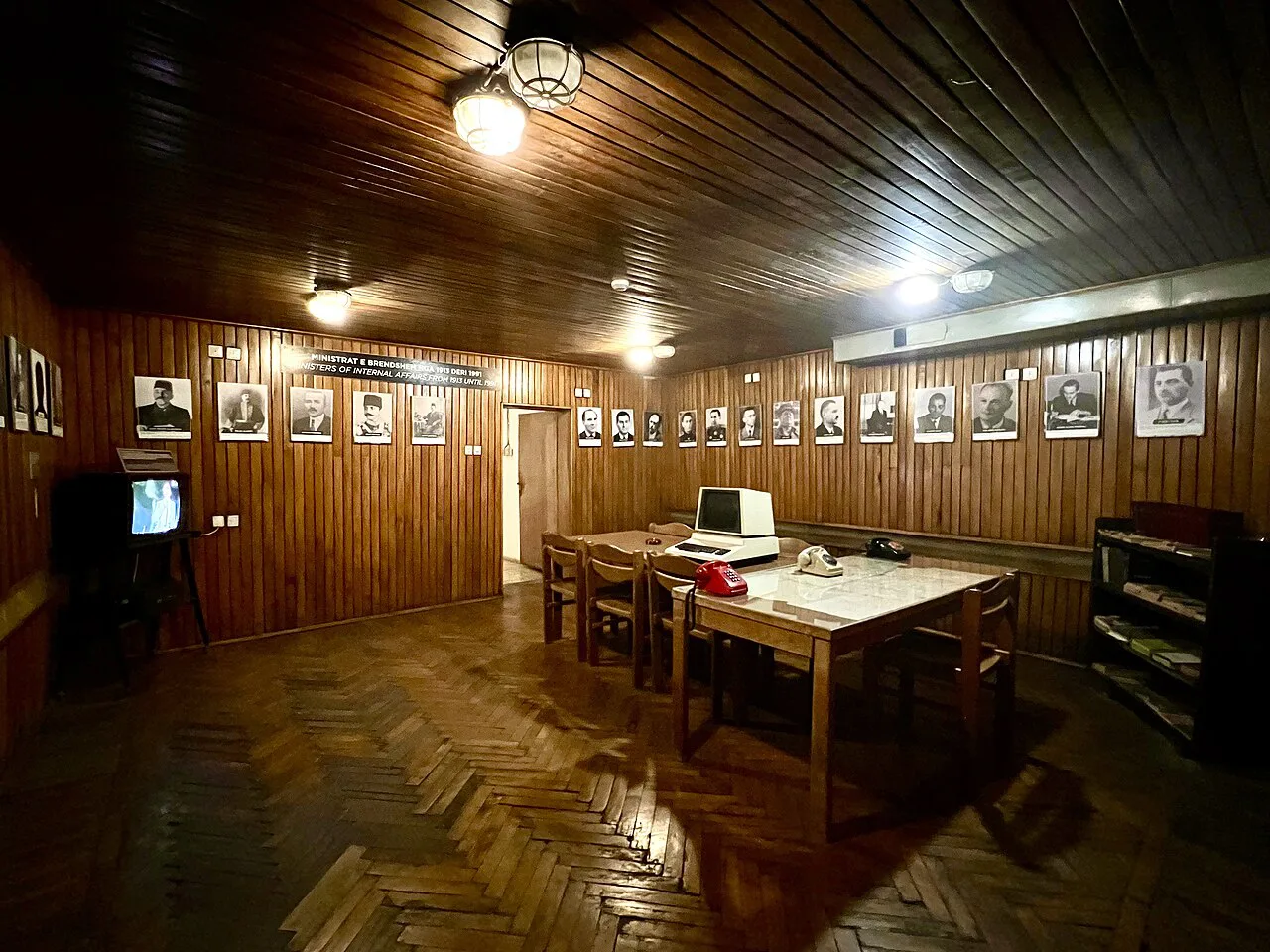 A wood-panelled room with photographs on display inside Bunk'Art 2.