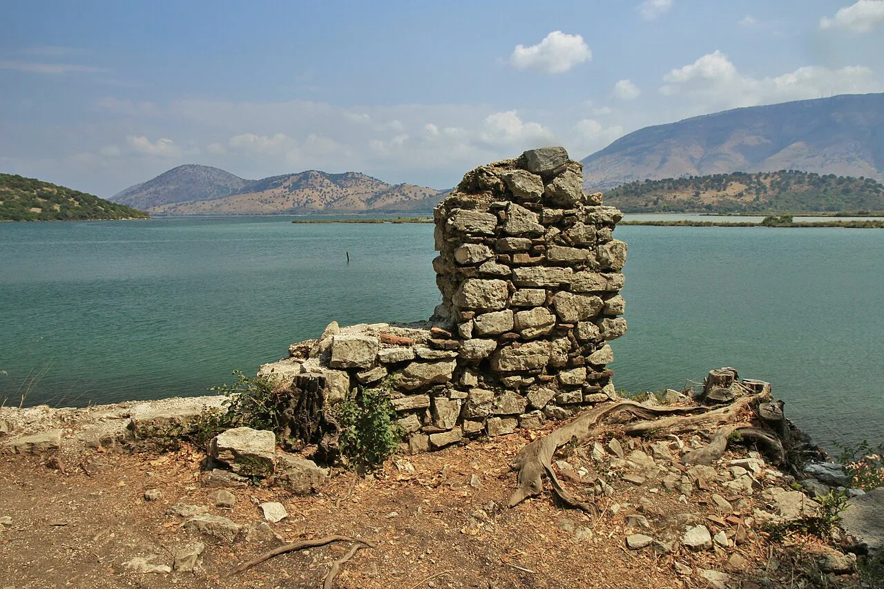 A ruined stone wall beside Lake Butrint.