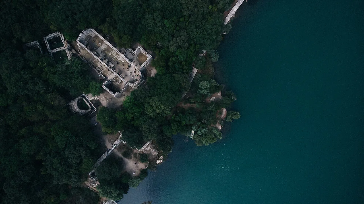 Aerial view of a ruined church in Butrint National Park beside the lake.