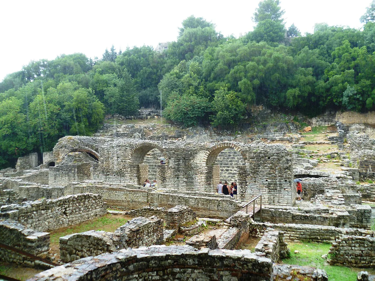 Excavated ruins among the trees at the Butrint archaeological site.
