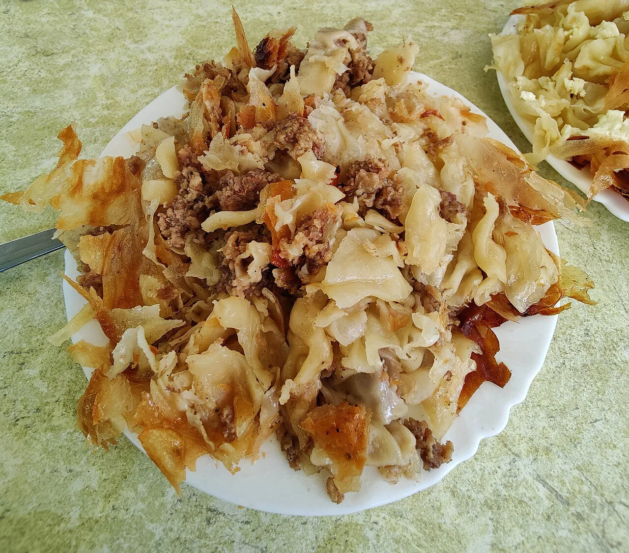 Meat byrek served with chips.