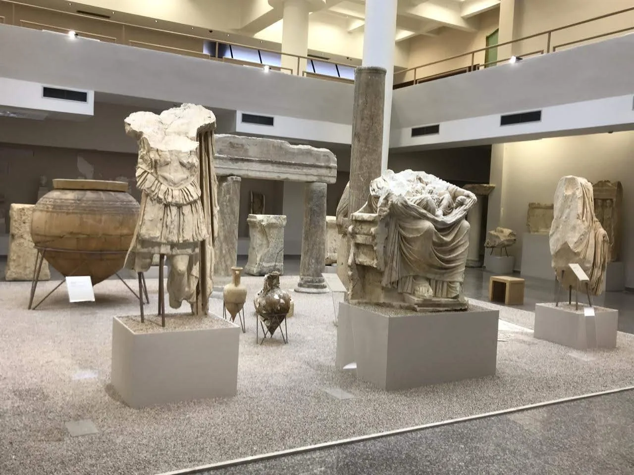 Statues and amphorae on display inside the Durrës Archaeological Museum.