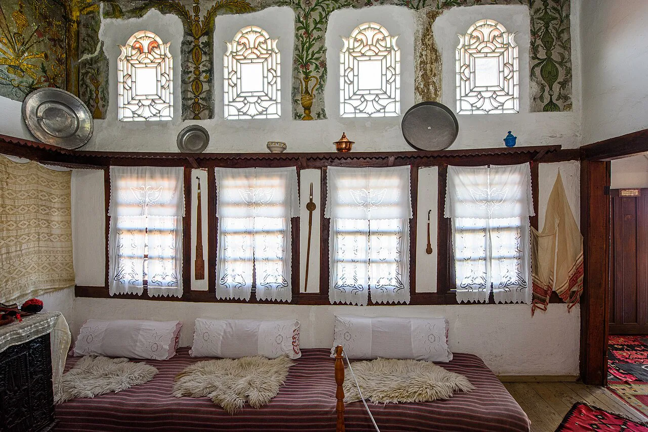 A traditional reception room with carved woodwork in the Ethnographic Museum of Krujë.