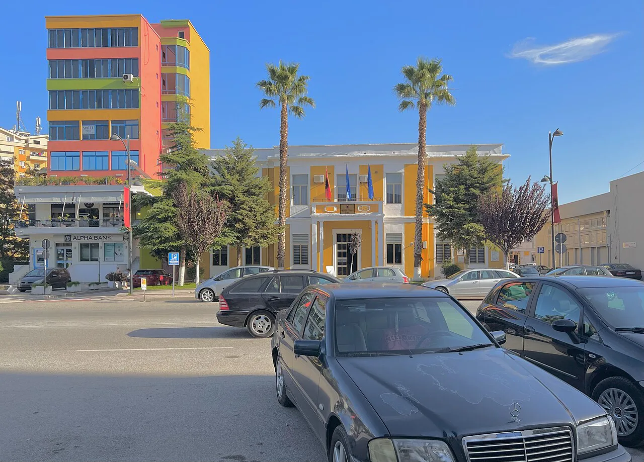 Colourful buildings and palm trees in central Fier.
