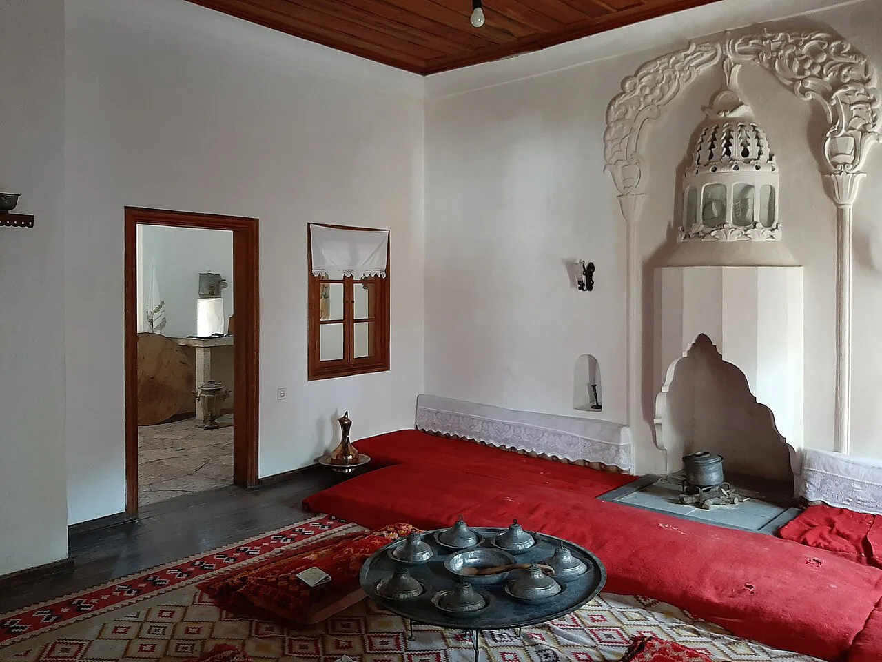 A room with a carved fireplace in the Ethnographic Museum of Gjirokastër.