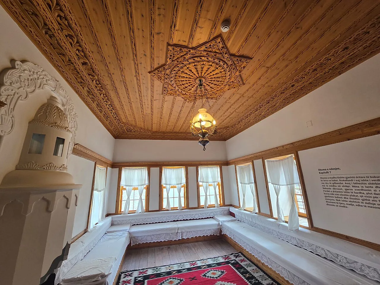 A sitting room with a carved wooden ceiling in the Ismail Kadare House, Gjirokastër.
