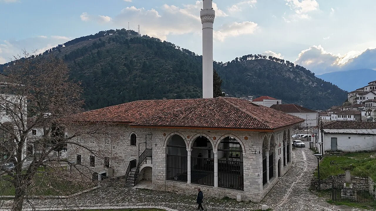 The King's Mosque in Berat with its minaret and the hills behind.