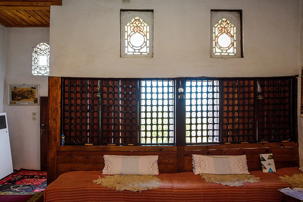 A raised sitting area with latticed windows in the Ethnographic Museum in Krujë.