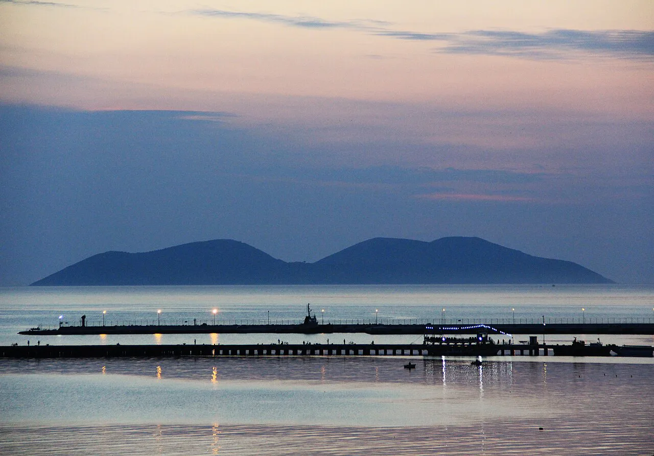 Dusk over the Bay of Vlorë with a pier in the foreground.