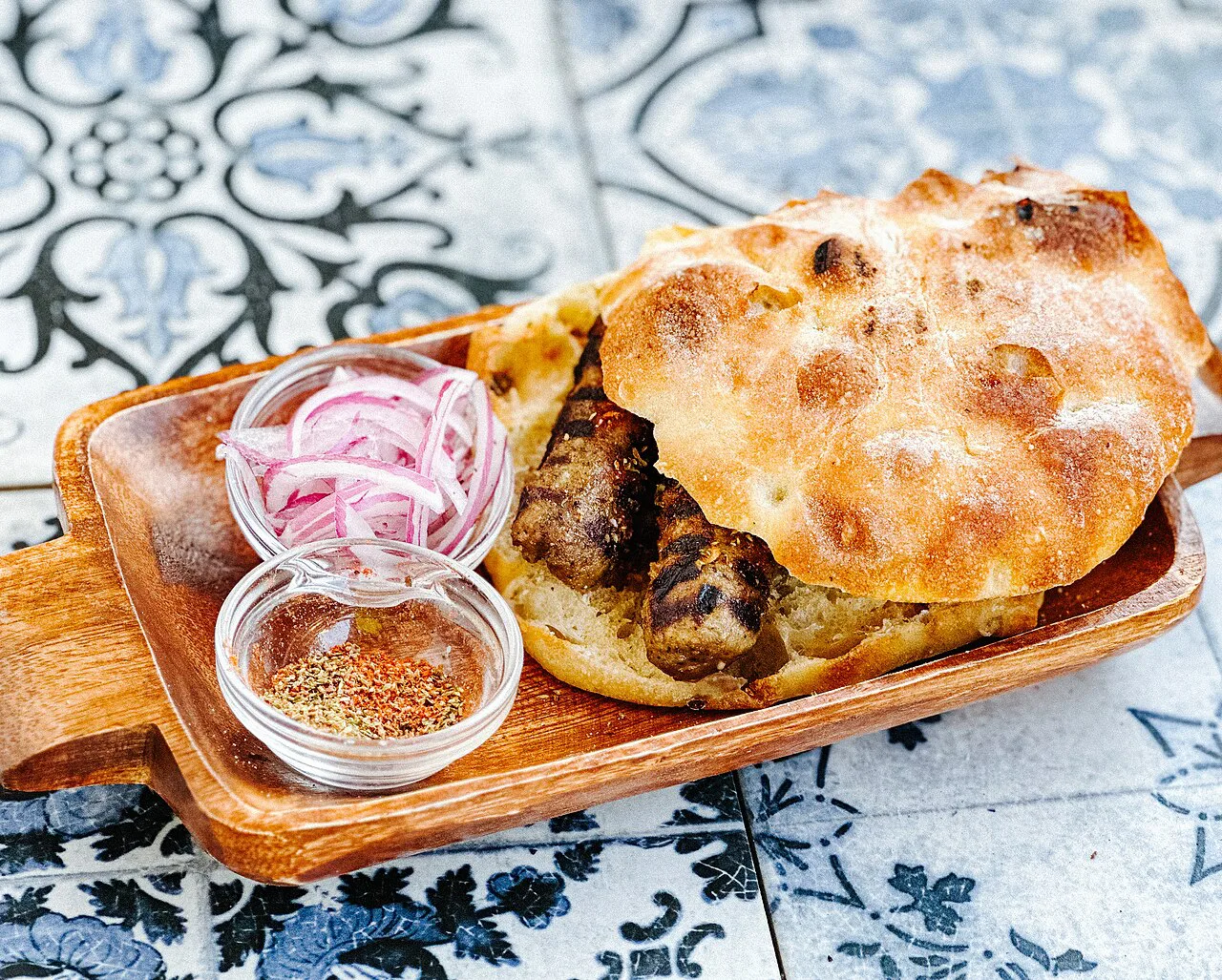 Qofte served in flatbread with pickled red onion and spices.