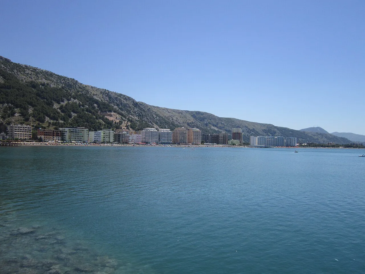 Shëngjin's seafront hotels seen across the water.