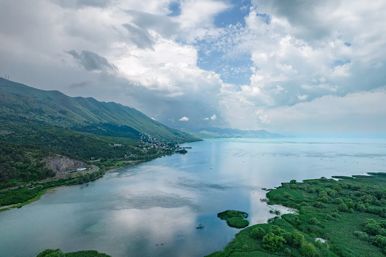 Lake Shkodër with wooded shores and mountains.