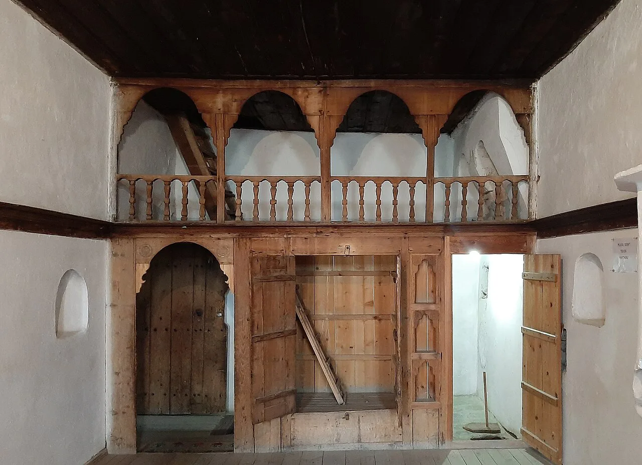 A wooden gallery and doorways inside Skenduli House in Gjirokastër.