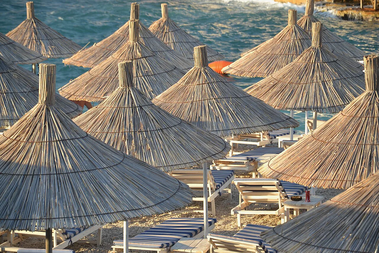 Straw parasols lining a beach in Ksamil.