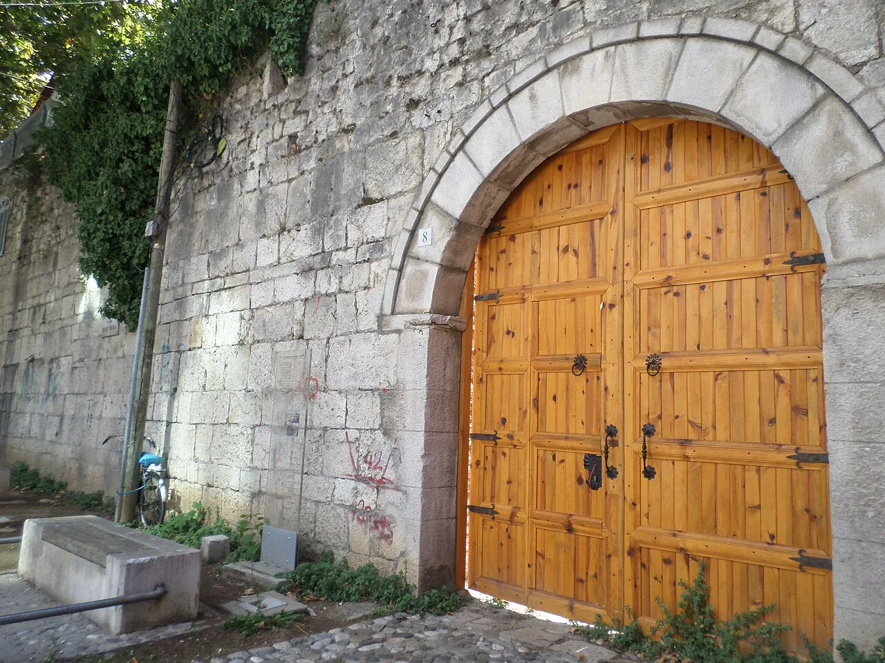 A wooden gate in the stone fortress walls of Tirana Castle.