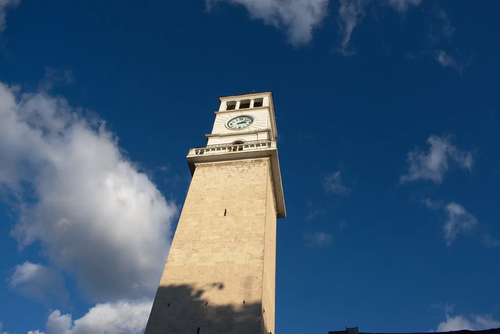 The Clock Tower of Tirana against a blue sky.
