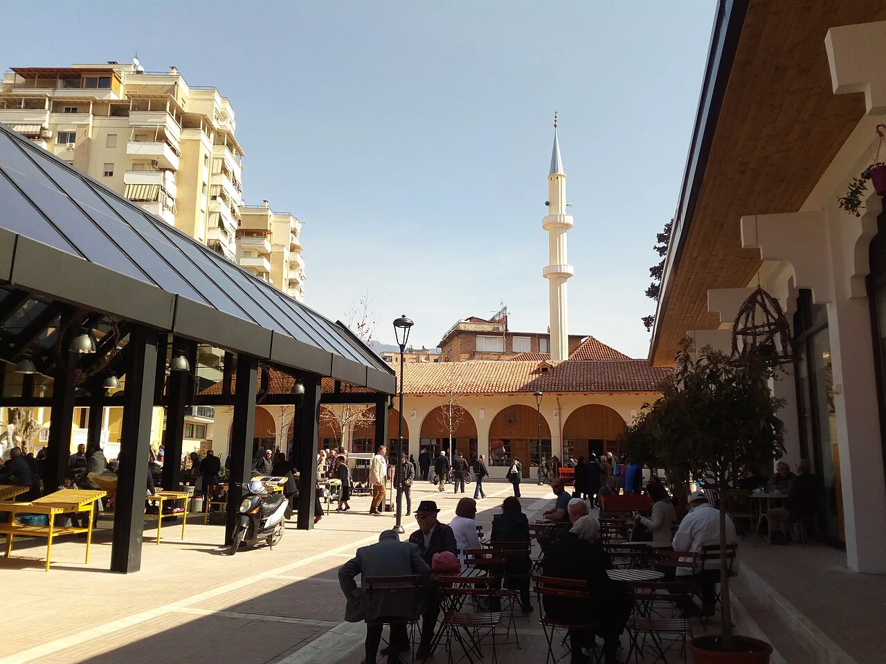 The covered market hall of Pazari i Ri in Tirana, with a minaret behind.