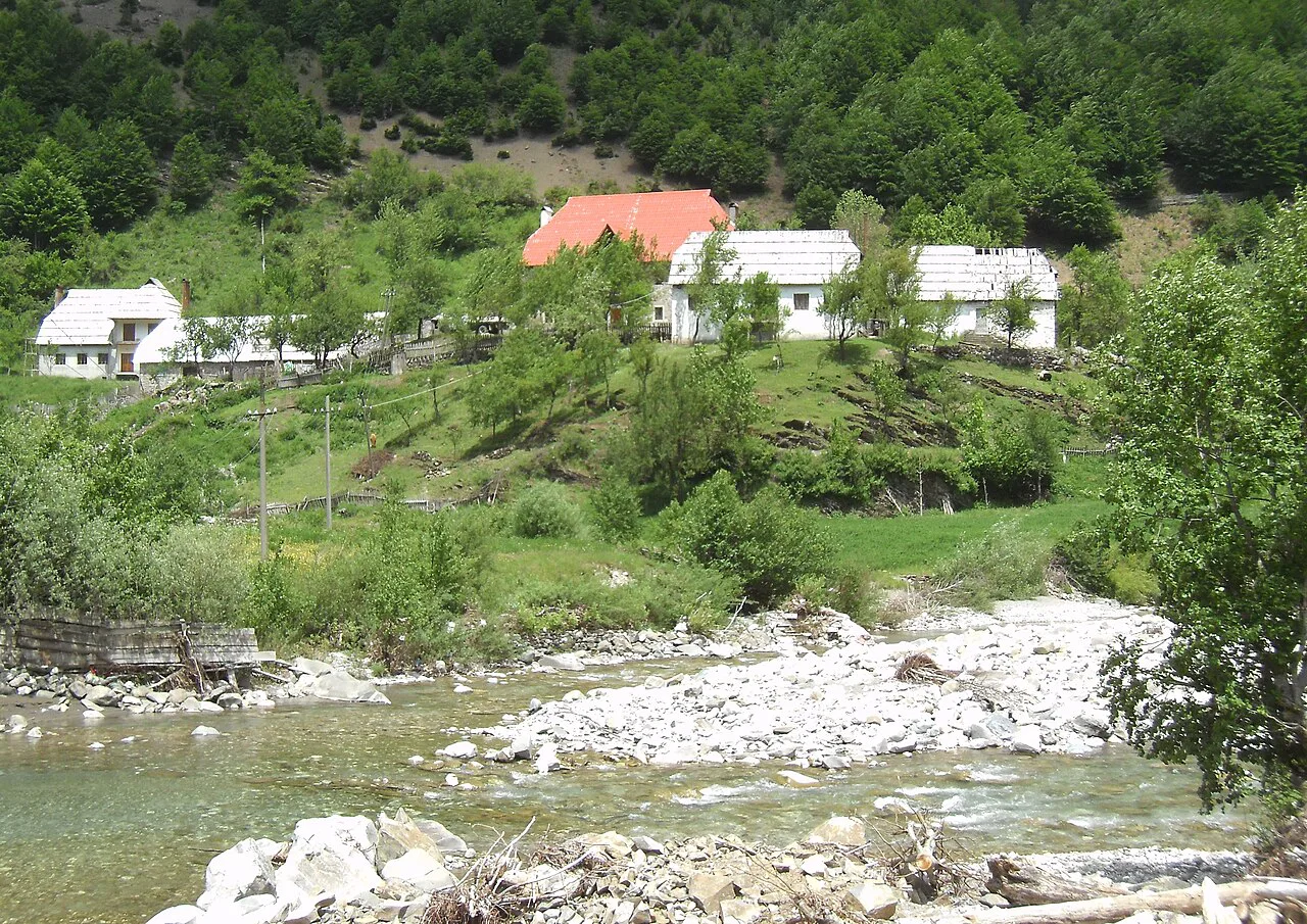 Houses above a stony riverbed in Vermosh.