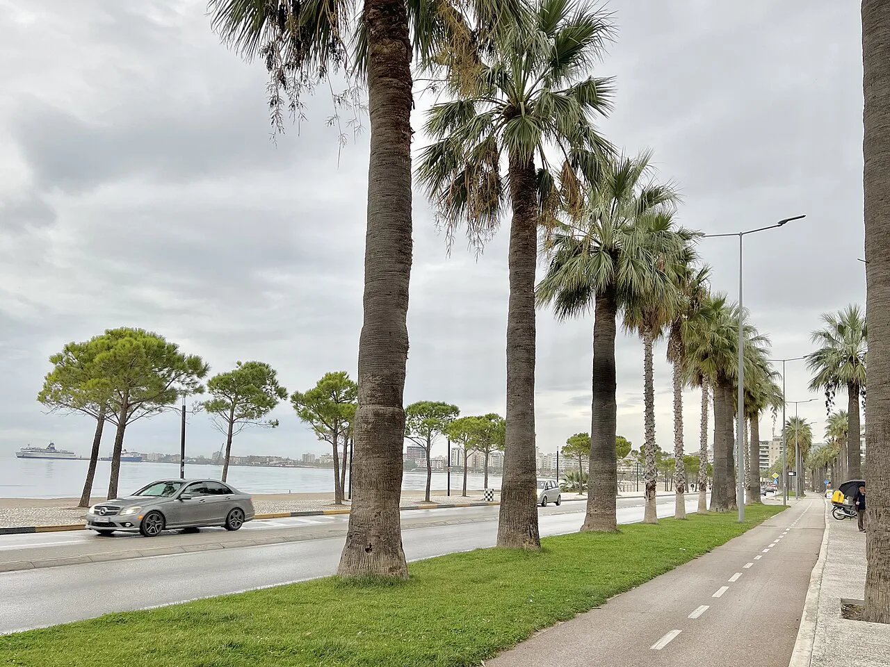 A palm-lined seafront street in Vlorë.