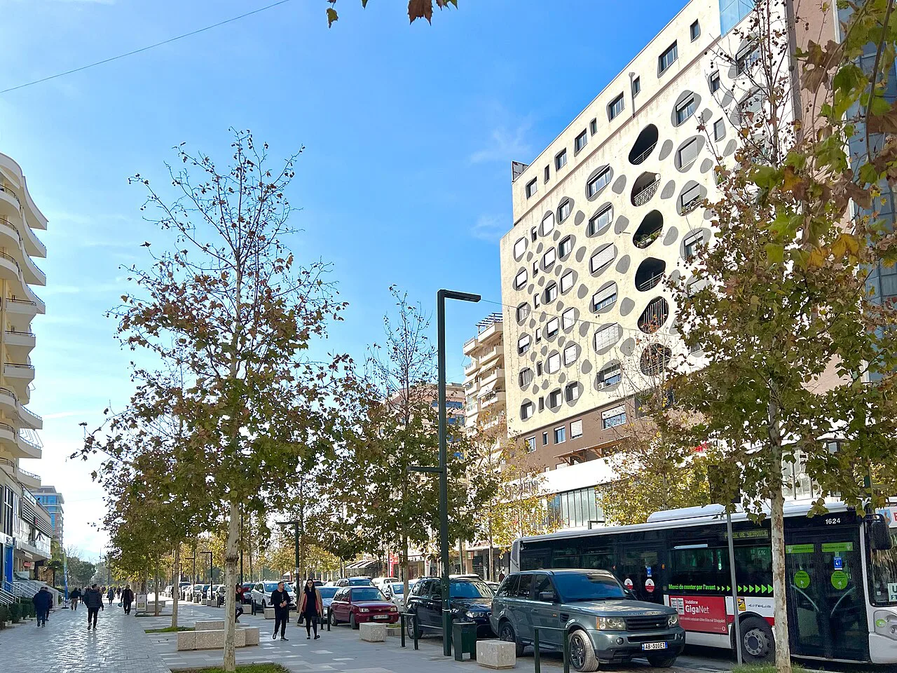 A busy street with modern high-rise buildings in central Vlorë.