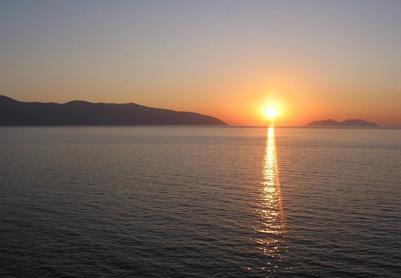 The sun dipping towards the hills across the Bay of Vlorë.